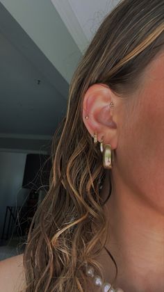 a close up of a person wearing some kind of earring with pearls on it