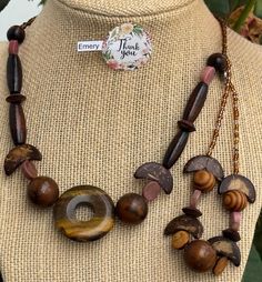 This unique and necklace and bracelet features a beautiful blend of natural wood beads, accented by a stunning tiger's eye centerpiece. The set has earthy tones and organic shapes create a relaxed and free-spirited vibe. Perfect for adding a touch of boho chic to your wardrobe, this necklace is a versatile and eye-catching piece Wood Bead Jewelry, Beaded Necklace And Bracelet, Wood Beads Jewelry, Necklace And Bracelet, Jewelry Boho, Bead Jewelry, Free Spirited, Tiger's Eye, Organic Shapes