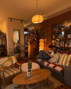 a woman sitting on top of a couch in a living room next to a coffee table