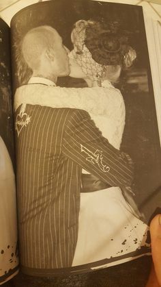 an old photo of a man kissing a woman on the cheek in a book with pages spread out