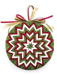 a green ornament with red and white designs on it