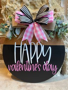 a wooden sign that says happy valentine's day with a bow on the front