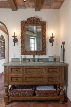 a bathroom with a sink, mirror and two wicker baskets on the counter top