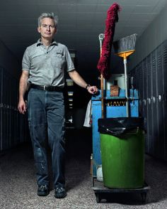 a man standing next to a dustbin with a mop on top of it