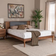 a large bed sitting in a bedroom next to a wooden dresser and window sill