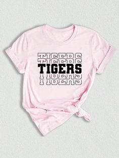 Introducing our Tigers Mascot Shirt, the perfect apparel for all the Tiger fans out there!  Whether you're a proud member of the Tigers team, a dedicated fan, or simply want to show your support, this shirt is a must-have addition to your collection. Designed with the iconic Tigers Mascot, this shirt captures the spirit and energy of your beloved team. Made with high-quality materials, this Tigers School Shirt is not only comfortable but durable as well. You'll love the softness of the fabric ag Fan Apparel T-shirt With Letter Print, Fan Gear T-shirt With Letter Print, Crew Neck, Fan Gear Letter Print T-shirt, Crew Neck, Fan Gear Letter Print Crew Neck T-shirt, Collegiate Tops With Screen Print For Fan Merchandise, School Spirit Short Sleeve T-shirt With Letter Print, Band Merch Cotton T-shirt For Fans, Team Spirit T-shirt With Logo Print And Crew Neck, Cotton Slogan T-shirt For Fan Gear