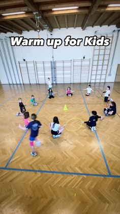 a group of children are playing with frisbees in an indoor gym area