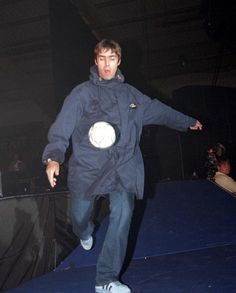 a man standing on top of a blue platform holding a white frisbee in his hand