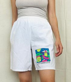 "90s Cotton Board Shorts - Los Angeles Print - Small Size Small modeled on a Small Adjustable inner draw string Waist 22\"unstretched 33\"fully stretched 42\"hip 18\"length small marking on top of print design but doesn't take away from overall look" White Relaxed Fit Retro Bottoms, Spring Streetwear Shorts With Elastic Waistband, 90s Style Summer Streetwear Pants, Summer Graphic Print Lounge Pants, Summer Graphic Print Pants For Loungewear, Graphic Print Pants For Summer Loungewear, White Knee-length Shorts For Streetwear, Beach Graphic Print Cotton Bottoms, Beach Cotton Bottoms With Graphic Print