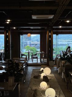 an empty restaurant with tables and chairs in front of large windows overlooking the cityscape