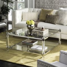 a living room filled with furniture and a glass table on top of a rug in front of a window