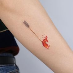 a woman's arm with a red ink splattered on it and an arrow