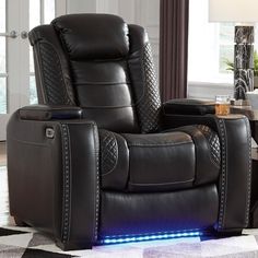 the reclining chair has blue lights on it's arm and footrests