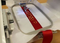 sewing machine with red and white ribbon on it's side, next to scissors