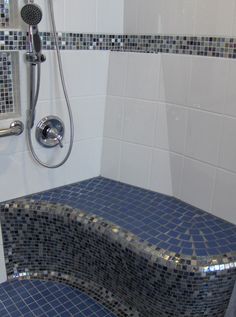 a bathroom with blue and white tiles on the shower wall