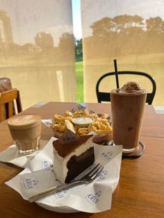 there is a piece of cake on the table with two cups of coffee next to it