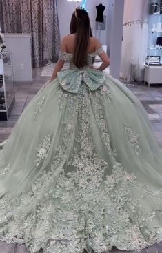 a woman in a green ball gown looking at herself