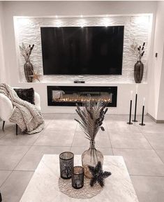 a living room with white furniture and a flat screen tv mounted above the fire place