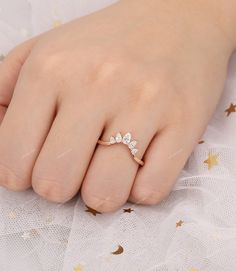 a close up of a person's hand wearing a gold ring with three leaves on it