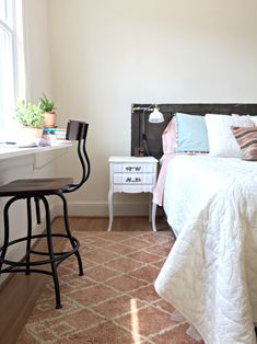 a white bed sitting next to a window in a bedroom