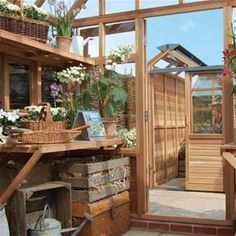 a wooden greenhouse with lots of plants and flowers in the house's window sill