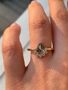 a woman's hand with a diamond ring on top of her finger and an engagement band