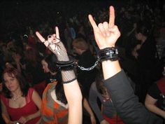 a group of people at a concert with their hands in the air and chains around them