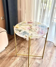 a table with flowers painted on it in front of a window