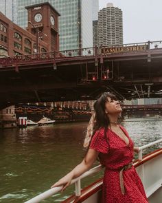 a woman in a red dress is standing on a boat looking up at the sky