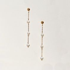 Stunning worn, these tiny triple tiered freshwater pearls float on delicate 14k gold filled chain. The 3mm wide pearls set along a whisper of chain, create a super chic minimal look that will offset a harder masculine outfit, and work equally well with feminine, bridal looks.  The ball ear post and backing are both 14k gold filled. 14k gold filled metal does not flake off and contains significantly more gold than regular 'gold plated' jewelry. It is considered second in quality to solid gold. Al Dainty Pearl White 14k Gold Filled Pearl Earrings, Dainty Pearl Drop Linear Earrings, Dainty Pearl Dangle Linear Earrings, Dainty Linear Earrings With Pearl Charm For Gift, Dainty 14k Gold-filled Pearl Charm Earrings, Delicate Yellow Gold Dangle Pearl Earrings, Elegant Everyday Jewelry With Dangling Beads, Dainty Pearl Linear Earrings For Formal Events, Dainty Dangle Pearl Earrings