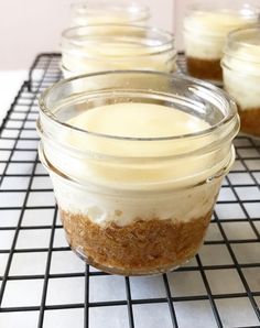 small jars filled with dessert sitting on top of a cooling rack