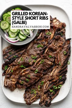 grilled korean style short ribs served with cucumbers and pickles on a white platter