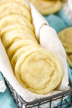 a basket filled with cookies sitting on top of a blue cloth covered table next to other plates