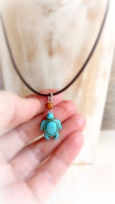 "Blue turquoise magnesite stone turtle hangs on mahogany wood bead and  brown leather cord , that finished with silver or gold metal findings . Beautiful pendant for any summer activity ! If you are looking for white turtle necklace - it's her : https://www.etsy.com/listing/467315027/sea-turtle-howlite-choker-turquoise?ref=shop_home_active_3 Size : 18 \" cord           1 \" 1/4 '  pendant with loop   If you'll need a different size - please convo me." Adjustable Turquoise Amulet Necklace, Handmade Turquoise Jewelry With Waxed Cord, Handmade Adjustable Turquoise Necklace As Gift, Spiritual Turquoise Jewelry With Adjustable Cord, Brown Pendant Jewelry With Adjustable Cord, Adjustable Turquoise Pendant Necklace With Spiritual Style, Adjustable Spiritual Turquoise Pendant Necklace, Spiritual Adjustable Turquoise Necklace Gift, Handmade Adjustable Brown Turquoise Necklace