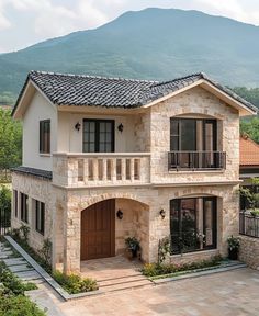 a large house with a balcony and two balconies on the second floor is shown in front of a mountain range