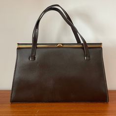 Description: Vintage Linslade London Brown Structured Top Handle Handbag. Made in England. Gold Tone Hardware. Suede Interior with Pocket. Couple of Small Marks to Back. Measurements: Width at Widest Point: 27.5cm, Height: 20cm, Strap to Bag: 15cm Handbag Inspiration, London Brown, Structured Top, Purse Vintage, Top Handle Bags, Top Handle Handbags, Vintage Purses, Vintage Handbags, Purses And Handbags