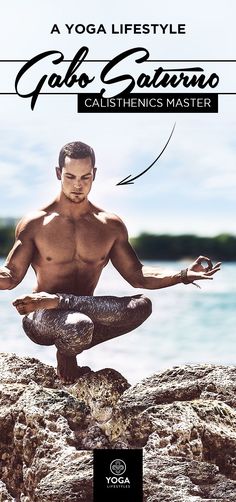 a man sitting on top of a rock next to the ocean with his hands in the air