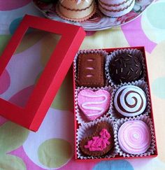 there are many different types of cupcakes in the box on the table next to each other