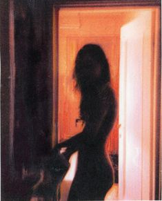 a woman standing in front of an open door with her back to the camera,