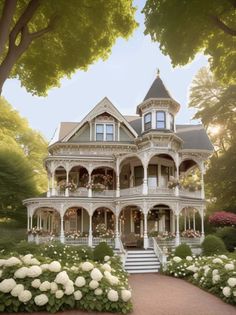 a large white house sitting in the middle of a lush green field with lots of flowers