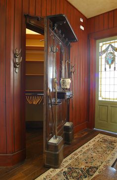 an antique grandfather clock in the corner of a room with wood paneling and stained glass windows