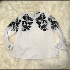 Zara- White Bell Sleeves White Shirt With Black Sequin And Velvet Embroidery Xs. Nwt- This Classic White Shirt Is Taken To Another Level With The Exquisite Black Pattern Of Flowers And Leaves That Is Embellished With Subtle Sequins And Velvet Fabric. The Bell Sleeves Top It Off. Elegant Blouse From Start To Finish. Elegant Zara Embroidered Top For Spring, White Embroidered Top For Fall, Elegant Crew Neck Top With Floral Embroidery, White Crew Neck Blouse With Floral Embroidery, Zara Elegant Embroidered Top For Spring, Zara Blouse With Floral Embroidery For Fall, Chic White Blouse With Embroidered Sleeves, White Crew Neck Blouse With Embroidered Hem, White Long Sleeve Blouse With Embroidered Hem