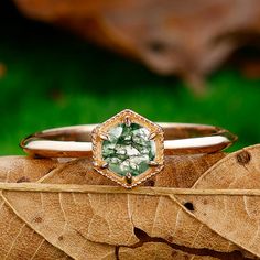 a green ring sitting on top of a leaf