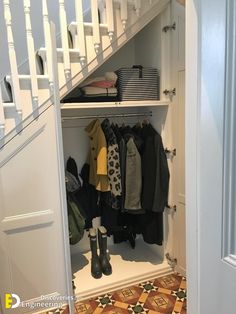 an open door to a closet with clothes and boots hanging on the shelves next to it