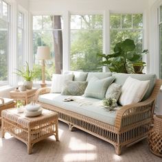 a living room with wicker furniture and large windows