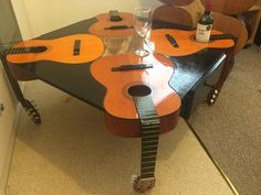 a guitar shaped coffee table with wine glasses on it