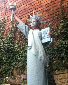 a statue of liberty holding a sign in front of a brick wall