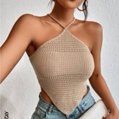 a woman wearing a crochet halter top with her hands in her pockets