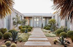 a house that has some plants in the front yard and walkway leading up to it