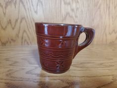 a brown cup sitting on top of a wooden table